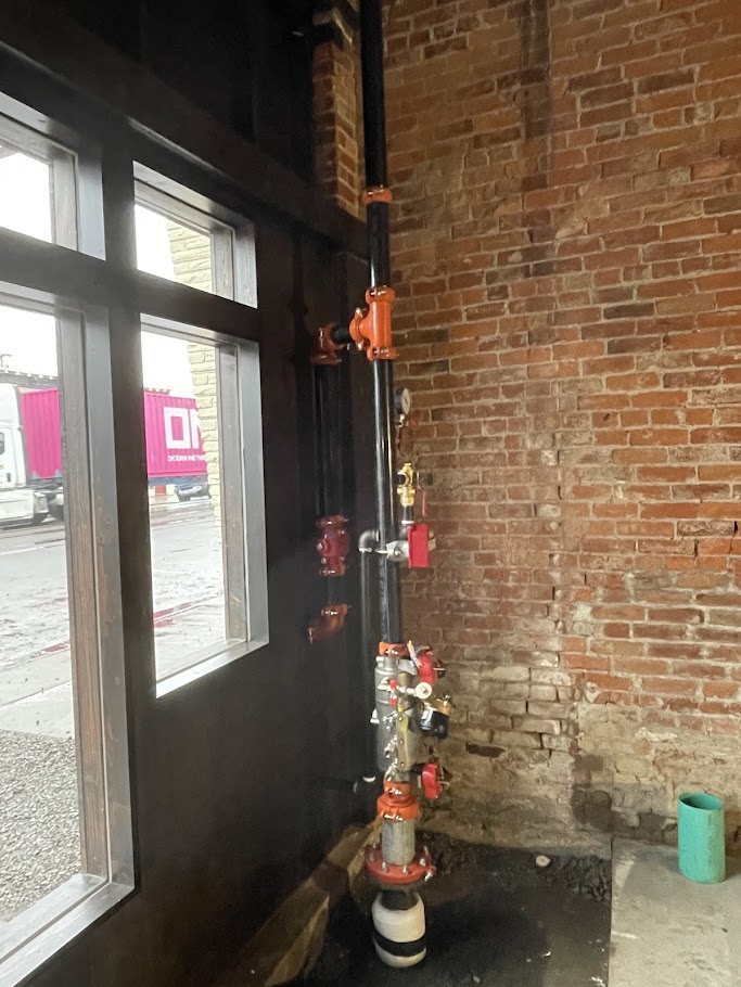 New fire sprinkler riser against original brick in a historic building, Newberg, Oregon